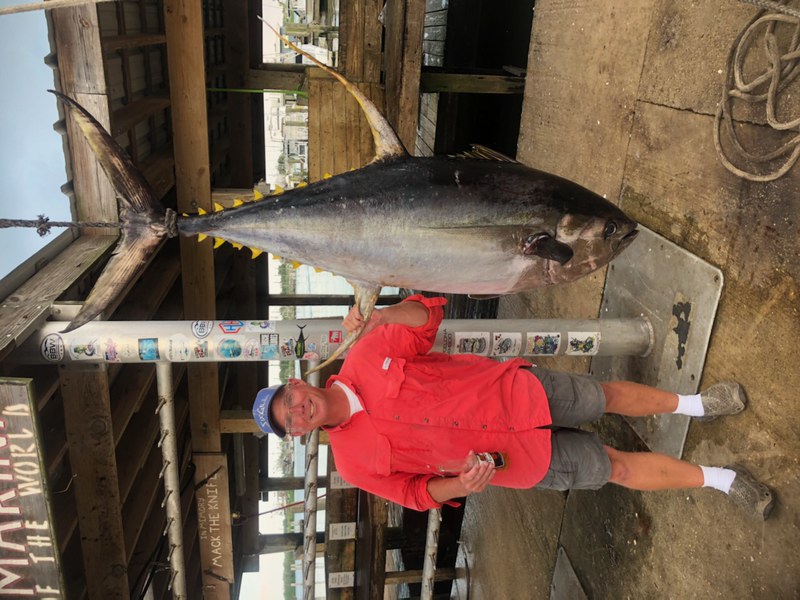Man standing next to big yellowfin tuna.