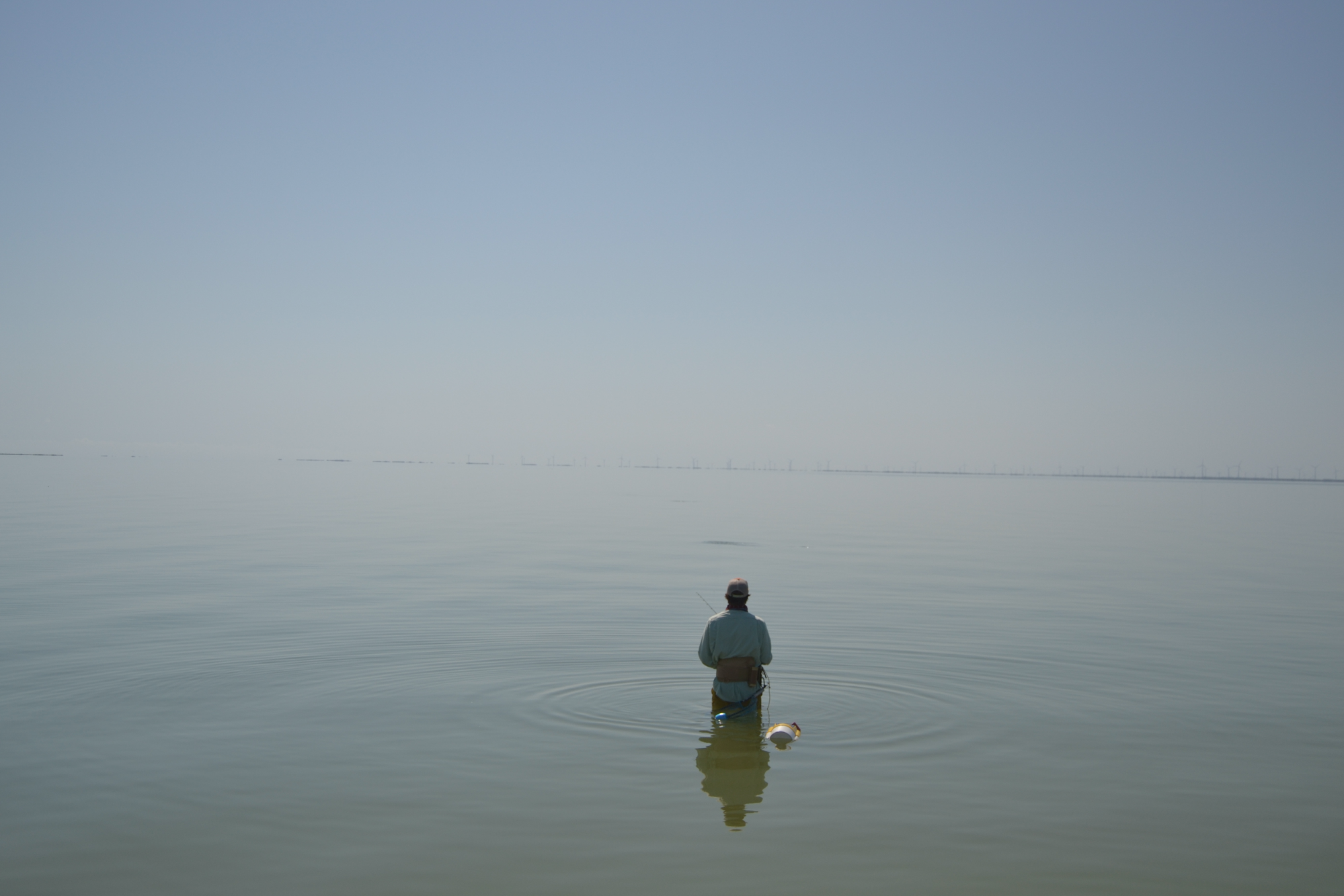 Man wading in water fishing for trout